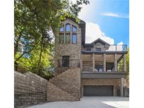 Stunning elevation of brick home with multi-level decks and grand staircase, complemented by a convenient garage at 1260 Monroe Ne Dr, Atlanta, GA 30306