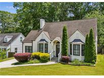 Charming home featuring a brick facade, manicured lawn, and lush landscaping at 2545 Tilson Se Dr, Atlanta, GA 30317