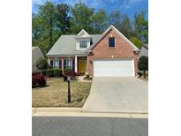 Charming single-Gathering home featuring a brick facade, two-car garage, manicured lawn, and a vibrant yellow front door at 3427 Hampreston Nw Way, Kennesaw, GA 30144