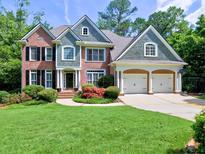 Charming two-story brick home with a well-manicured lawn and a two-car garage at 658 Vinings Estates Se Dr, Mableton, GA 30126