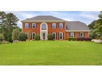 Charming two-story brick home with a large front yard and mature landscaping, perfect for families or those who enjoy outdoor space at 1197 Kenilworth Trce Trce, Snellville, GA 30078