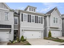 Charming townhome featuring a two-car garage, modern design elements, and well-maintained landscaping at 1247 Winterhaven Dr, Cumming, GA 30041