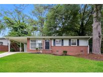 Charming single-story home with brick accents, a carport, and a well-manicured lawn at 1112 Evelyn Drive Dr, Forest Park, GA 30297