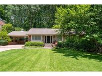 Charming single-story home with a well-manicured lawn and lush landscaping at 2917 Rockingham Nw Dr, Atlanta, GA 30327