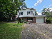 Charming two-story home with brick and vinyl siding, a gravel driveway and a well-maintained front lawn at 3400 Elm Creek Nw Dr, Marietta, GA 30064
