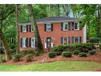 Charming brick home with black shutters and a beautifully landscaped front yard at 1209 Colony Cir, Marietta, GA 30068