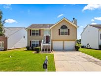 Charming two-story home with a well-maintained lawn and a two-car garage at 11833 Spring Lake Way, Fayetteville, GA 30215