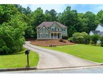 Gorgeous two-story home with a welcoming porch, mature trees, and a long driveway, offering serenity and privacy at 5741 Stonekirk Walk Northwest, Acworth, GA 30101