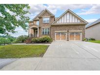 Two-story home with brick, a well-manicured lawn and a two car garage at 1057 Cotton Oak Dr, Lawrenceville, GA 30045
