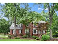 Charming brick two-story home with a well-manicured lawn and lush landscaping at 1418 Mill Path Loop, Lawrenceville, GA 30045