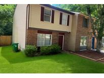 Two-story townhouse with red brick and siding, complemented by a lush green lawn at 5581 Marbut Rd, Lithonia, GA 30058