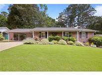 Charming brick home with a carport and a lush green lawn at 476 Concord Se Ln, Smyrna, GA 30082