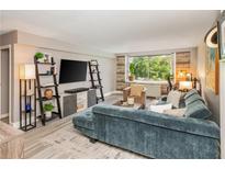 Bright living room featuring a plush blue sofa, modern shelving, and large windows with a lush green view at 2479 Peachtree Ne Rd # 201, Atlanta, GA 30305