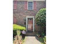 Charming brick home featuring a decorative front door with storm door and a well maintained front garden at 105 Glen Acres Ct, Decatur, GA 30035