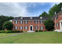 Classic brick building featuring black shutters, a black roof, and manicured landscaping at 2367 Cascade Rd # B7, Atlanta, GA 30311