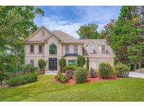 Stately traditional home featuring a well-manicured lawn and mature trees at 3314 Eagle Watch Dr, Woodstock, GA 30189