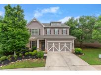 Charming two-story home with a well-manicured lawn, a two-car garage, and lovely landscaping, with gray paint and stone accents at 5901 Cobblestone Creek Cir, Mableton, GA 30126