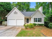Charming home featuring a two-car garage, a manicured lawn, and traditional architectural details at 10545 Virginia Pine Ln, Alpharetta, GA 30022