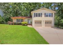 Charming home with a well-manicured lawn, covered porch, and two-car garage at 3196 Windfield Cir, Tucker, GA 30084