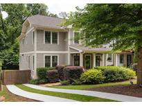 Charming home with inviting front porch, manicured landscaping, and a driveway with a green grass strip at 127 Oak Ln, Decatur, GA 30030