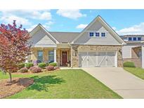 Charming home featuring a brick and siding facade, two-car garage, and beautifully landscaped front yard at 1758 Auburn Ridge Way, Dacula, GA 30019
