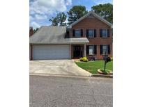 Charming two-story brick home with an attached two-car garage and well-maintained landscaping at 1165 Vineyard Ct, Stone Mountain, GA 30083