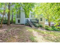 View of home featuring mature trees, a deck, stairs, and fresh landscaping at 1282 Shiloh Trail E, Kennesaw, GA 30144
