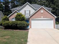 Charming two-story home featuring a brick facade, blue front door, and attached two-car garage at 2234 Oakland Springs Dr, Snellville, GA 30039