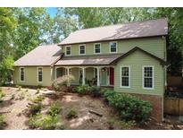 Charming two-story home with a welcoming front porch and lush, mature landscaping at 300 Stone Mill Trl, Atlanta, GA 30328