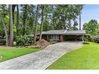 Charming brick home with a long driveway, a carport, and a well-manicured lawn at 1263 Blueberry Trl, Decatur, GA 30033