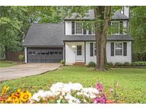 Charming two-story home featuring a well-manicured lawn, attached garage and mature trees at 410 Sheringham Ct, Roswell, GA 30076