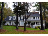 Charming two-story home with a inviting front porch, black shutters and manicured front yard at 440 Junction Trak, Roswell, GA 30075