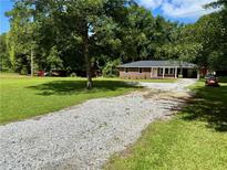 Charming one-story brick home with a long gravel driveway and a spacious front yard at 882 Campbell Rd, Covington, GA 30014