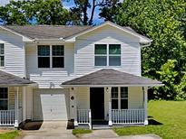 Charming two-story townhouse with a cozy front porch and well-maintained lawn at 1236 Pinedale Nw Cir, Conyers, GA 30012