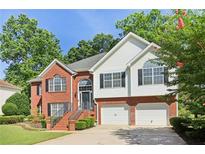 Charming two-story home features a brick and vinyl facade, two-car garage, and well-manicured landscaping at 4046 Water Hole Ct, Douglasville, GA 30135