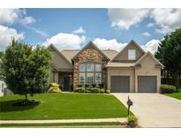 Charming home featuring a well-manicured lawn, stone accents, and an attached two-car garage at 1511 Rocky Knoll Ln, Dacula, GA 30019