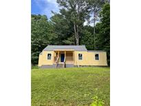 Charming yellow bungalow with a lovely front yard and a welcoming porch area at 451 Collier Ridge Nw Dr, Atlanta, GA 30318