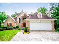 Charming two-story home with stone accents, red door, and well-manicured lawn at 7392 N Mitchell N Ct, Villa Rica, GA 30180