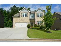 Charming two-story brick home with a well-manicured lawn and a two-car garage at 302 Aspen Valley Ln, Dallas, GA 30157