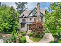 Charming home featuring a stone chimney, brick accents, and a well-manicured lawn at 400 Mabry Pl, Atlanta, GA 30319