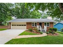 Charming brick ranch home with well-manicured lawn, stone walkway, attached garage, and inviting front porch at 3119 Medley Rdg, Decatur, GA 30033