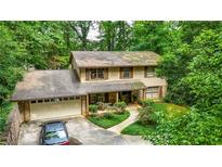 Charming two-story home nestled amongst mature trees with an attached garage and long drive at 3841 Brooklawn Ne Ct, Brookhaven, GA 30319