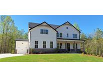 Beautiful two-story modern farmhouse with white siding, black trim, and a well-manicured lawn at 4525 Aiden Way, Cumming, GA 30041