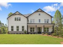 New construction two-story home with white siding, black trim, covered porch, and landscaped front yard at 4525 Aiden Way, Cumming, GA 30041