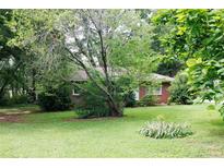 Cozy single-story brick home featuring a well-maintained lawn and mature trees at 127 Perry St, Loganville, GA 30052