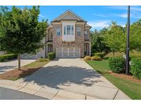 Charming brick townhome with two-car garage and manicured landscaping at 1858 Glenview Park Cir, Duluth, GA 30097