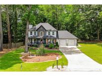 Charming two-story home featuring a well-manicured lawn, a two-car garage, and a inviting front porch with decorative trim at 3139 Fairview Dr, Snellville, GA 30078