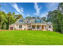 Charming home with a welcoming front porch, brick facade, well-manicured lawn, and professionally landscaped surroundings at 410 Iroquois Ct, Covington, GA 30014