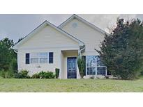 Charming single story home with a manicured lawn and a black front door at 155 Fairclift Dr, Covington, GA 30016