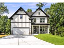 Beautiful two-story home with white siding, black trim, a two car garage, and well-manicured lawn at 4140 Camaron Way, Snellville, GA 30039